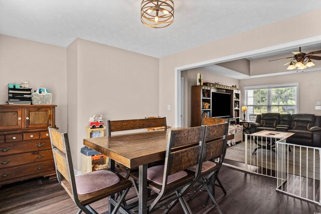 Dining space with dark wood-type flooring and ceiling fan | Image 8