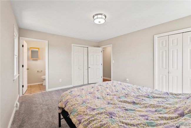 Carpeted bedroom featuring baseboards, two closets, and ensuite bath | Image 18