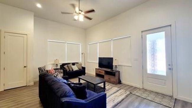 Living room with wood finished floors, a ceiling fan, and recessed lighting | Image 4