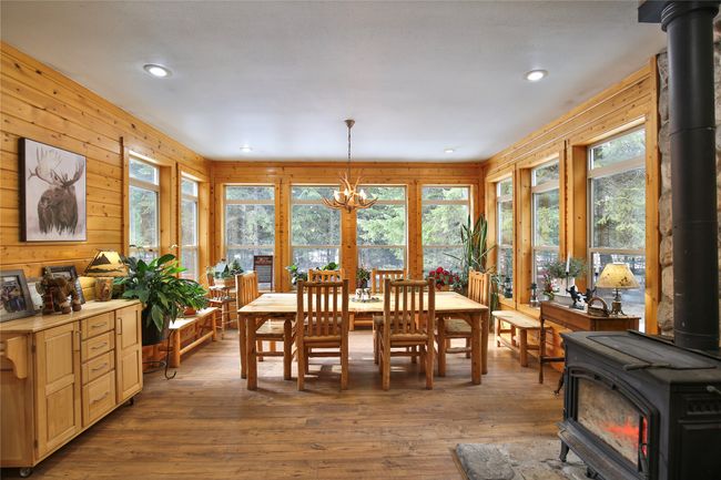 Dining space featuring a wood stove, a notable chandelier, wood finished floors, and recessed lighting | Image 9