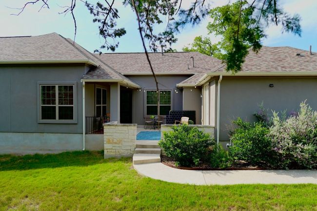 View of front of property with a front lawn, stucco siding, a shingled roof, and a patio | Image 4