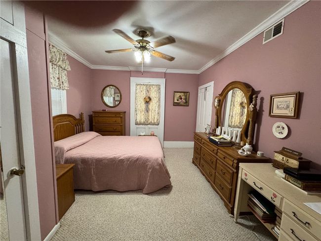 Bedroom featuring light carpet, ornamental molding, and a ceiling fan | Image 18