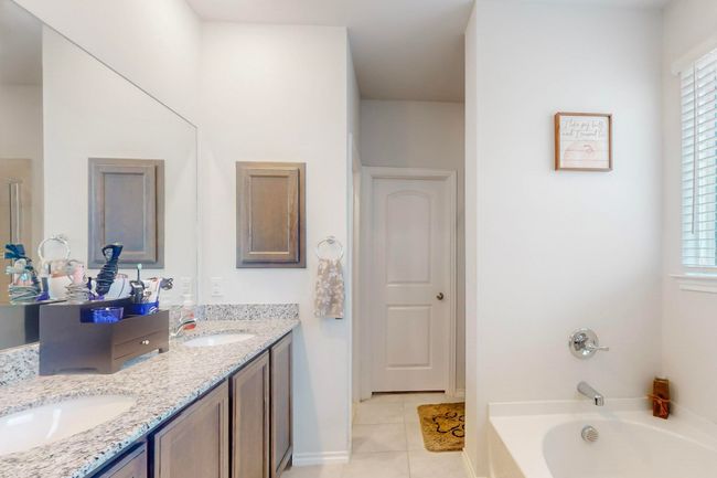 Full bathroom with a sink, double vanity, tile patterned flooring, and a garden tub | Image 14