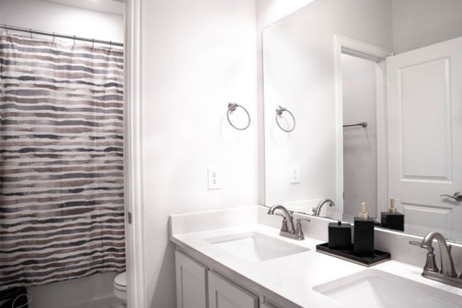 Bathroom with toilet, a sink, and double vanity | Image 19