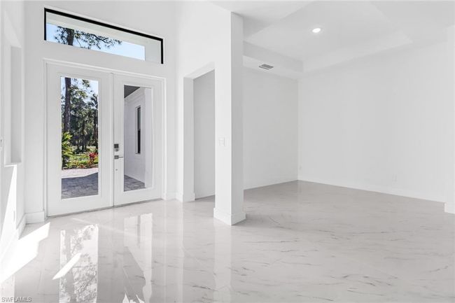 Doorway featuring light tile patterned floors, french doors, and a towering ceiling | Image 5