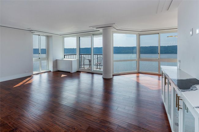 Spare room with a water view, dark wood finished floors, and expansive windows | Image 6