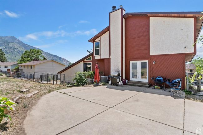 Rear view of house featuring french doors, a patio area, a mountain view, stucco siding, and a chimney | Image 35