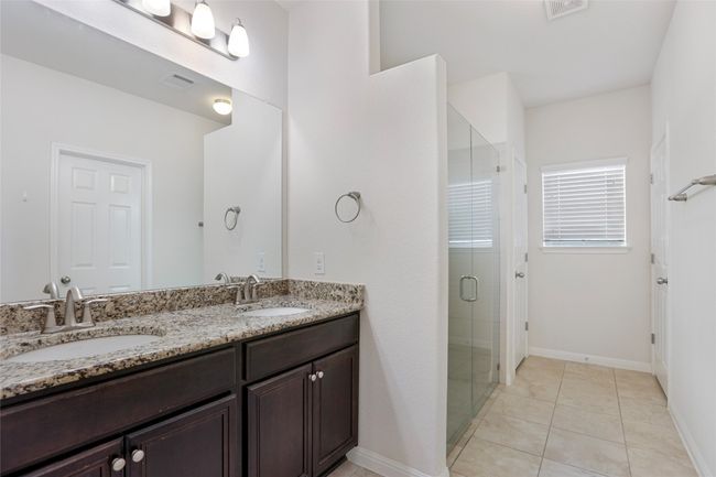 Bathroom featuring a stall shower, a sink, visible vents, and double vanity | Image 23