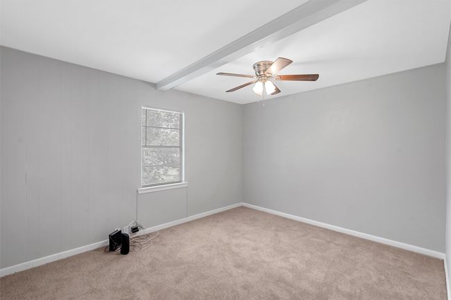 Unfurnished room with carpet flooring, beam ceiling, and a ceiling fan | Image 11