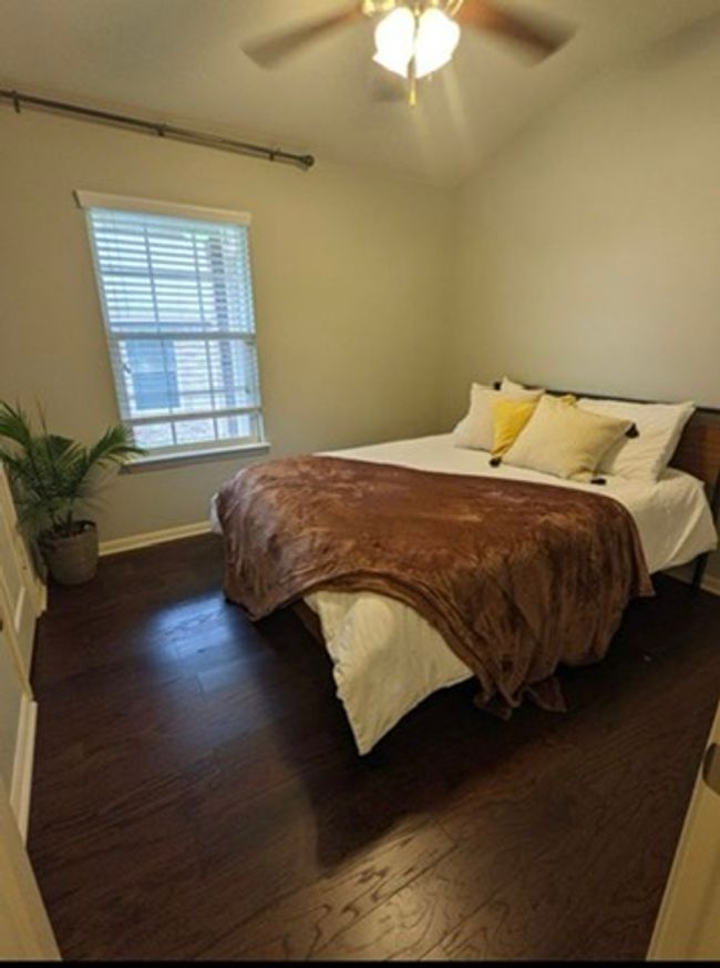 Bedroom featuring wood finished floors, vaulted ceiling, and a ceiling fan | Image 15