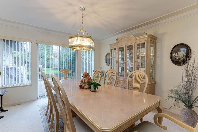 Dining room with light carpet, crown molding, visible vents, and baseboards | Image 7