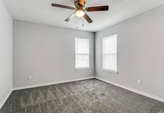 Spare room featuring baseboards, ceiling fan, and carpet | Image 6