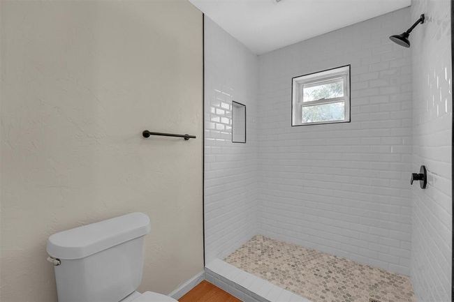 Bathroom featuring tiled shower, hardwood / wood-style flooring, and toilet | Image 33