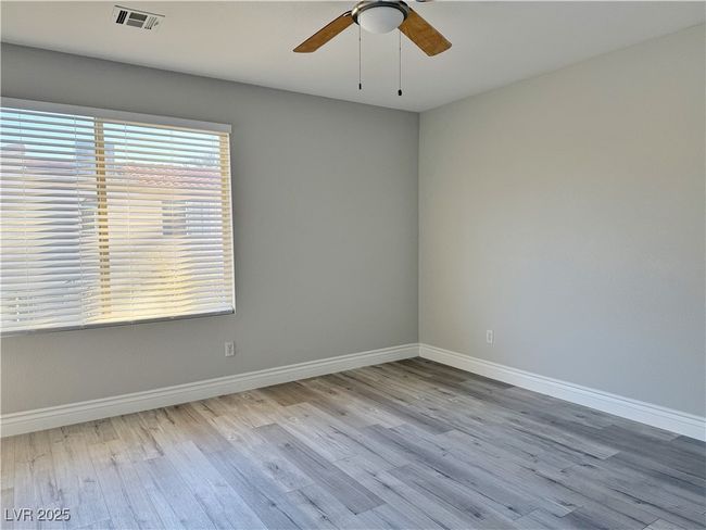 Unfurnished room with visible vents, baseboards, wood finished floors, and a ceiling fan | Image 26
