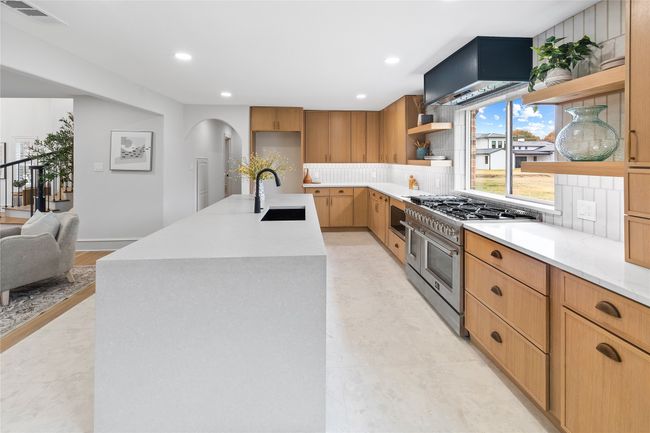 Kitchen with open shelves, high end range, decorative backsplash, recessed lighting, and arched walkways | Image 14