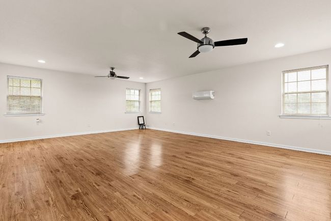 Empty room featuring ceiling fan, recessed lighting, a wall mounted AC, and light wood-style floors | Image 31