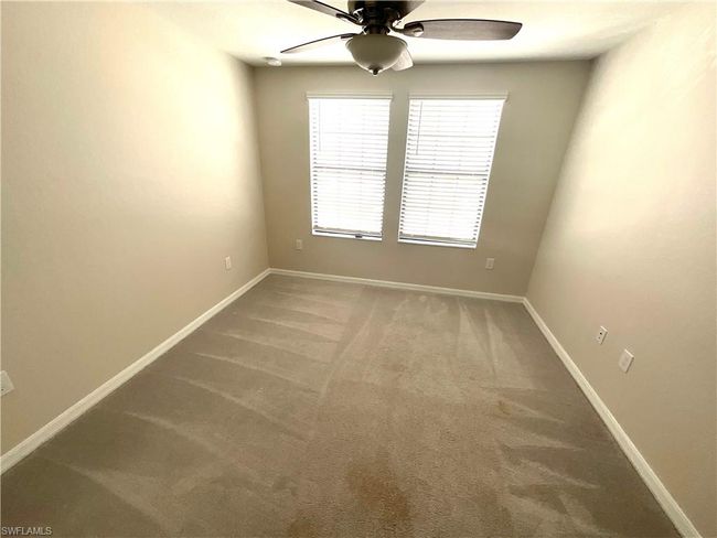 Carpeted empty room featuring a ceiling fan and baseboards | Image 19