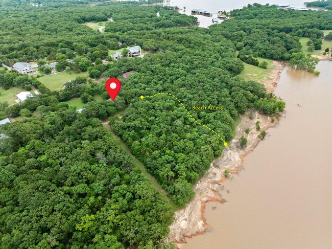 Drone / aerial view of a nearby body of water and a heavily wooded area | Image 11