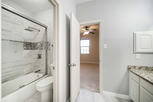Full bathroom featuring vanity, bath / shower combo with glass door, and ceiling fan | Image 29