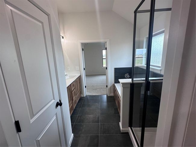 Full bathroom with plenty of natural light, tile patterned floors, lofted ceiling, and vanity | Image 7