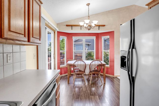 Dining area featuring lofted ceiling, a chandelier, dark wood-type flooring, and baseboards | Image 13