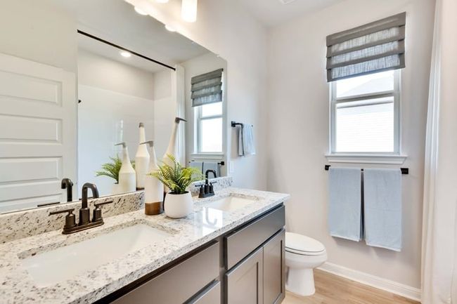 Bathroom with double vanity and wood finished floors | Image 12
