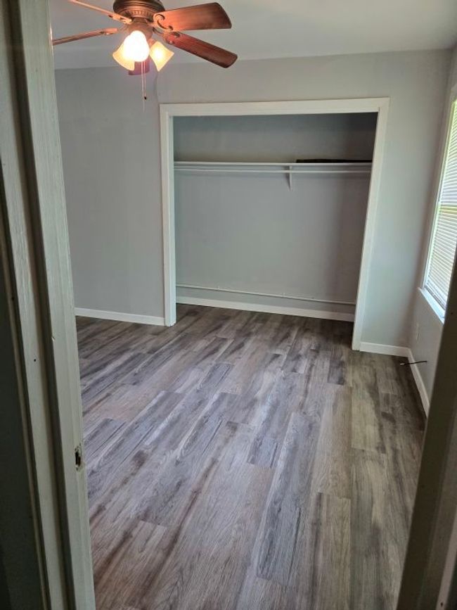 Unfurnished bedroom featuring a closet, wood finished floors, and ceiling fan | Image 18