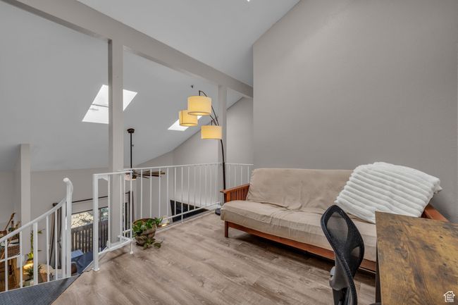 Living area with a skylight, high vaulted ceiling, and wood finished floors | Image 17
