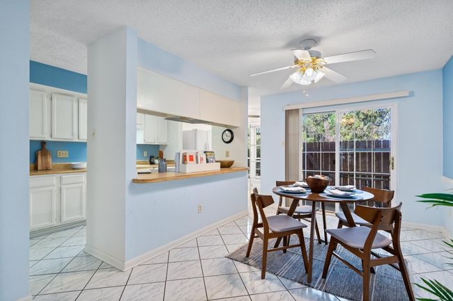 Dining space with baseboards, marble finish floor, a textured ceiling, and ceiling fan | Image 11