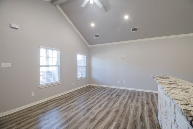Spare room featuring ornamental molding, wood finished floors, high vaulted ceiling, a ceiling fan, and recessed lighting | Image 6