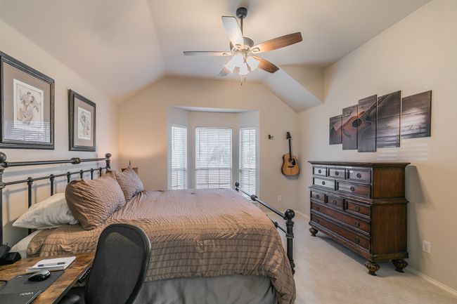 Bedroom featuring vaulted ceiling, light colored carpet, baseboards, and ceiling fan | Image 22