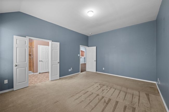 Unfurnished bedroom featuring carpet, baseboards, and lofted ceiling | Image 10