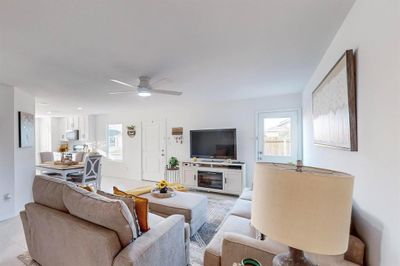 Tiled living room with ceiling fan and a healthy amount of sunlight | Image 2