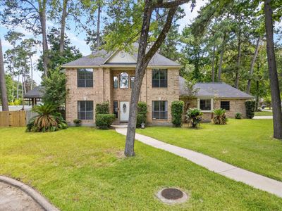 Two-story brick house with landscaped yard, surrounded by tall trees, featuring a gazebo and a well-manicured lawn. | Image 3