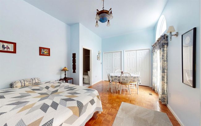 Bedroom with two closets, a chandelier, a high ceiling, baseboards, and ensuite bathroom | Image 28