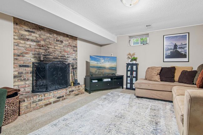 Cozy up in this lower level family room! Great place to watch movies, sporting events, or have a relaxing evening reading a book by the fire. | Image 16