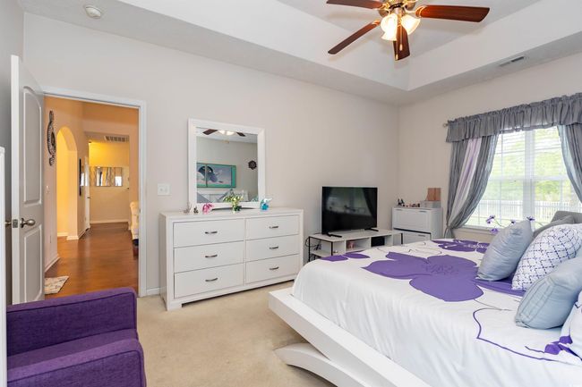 Bedroom featuring visible vents, arched walkways, ceiling fan, and light colored carpet | Image 12