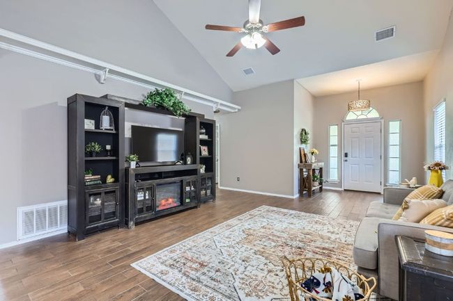 Living room featuring high vaulted ceiling, wood finished floors, and a ceiling fan | Image 4
