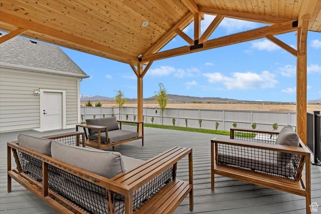Wooden deck featuring a fenced backyard, outdoor lounge area, and a mountain view | Image 34