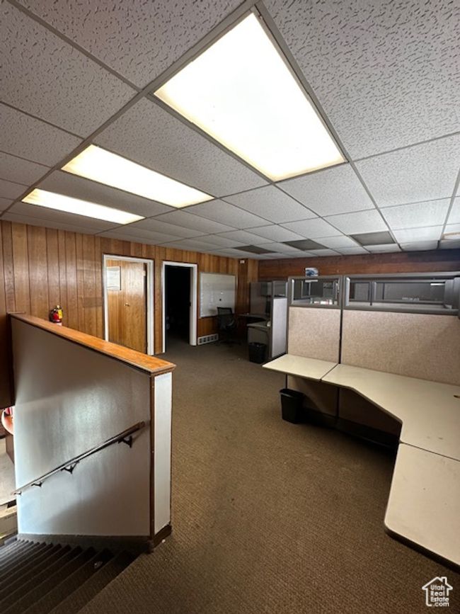 Interior space with carpet, a drop ceiling, and wooden walls | Image 14