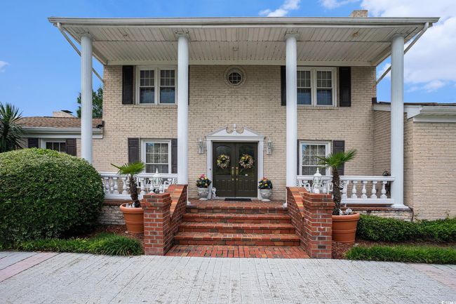 Greek revival house with a porch, brick siding, and french doors | Image 5