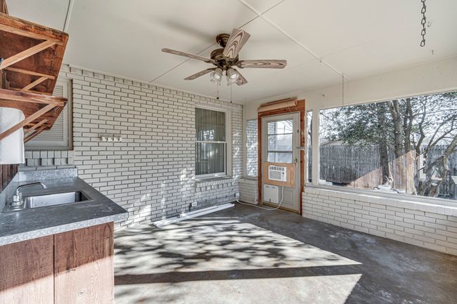 Porch with windows all around, countertop and sink for the convenience of outdoor enteratining. | Image 13