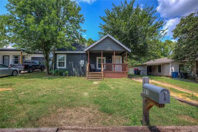 Bungalow-style house featuring covered porch and a front lawn | Image 2