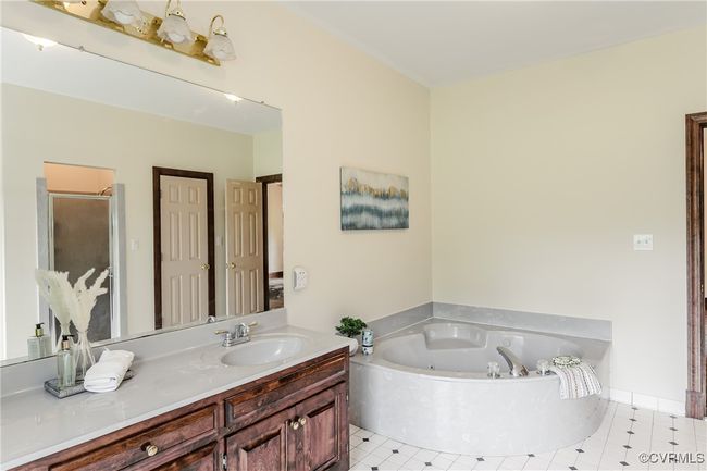 Full bathroom featuring a whirlpool tub, vanity, and a shower stall | Image 22