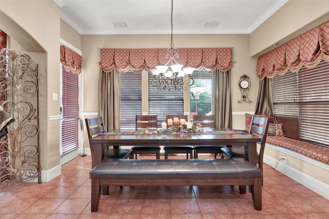 A charming breakfast nook has sunny windows on three sides with wonderful views of the patio, pool and putting green. | Image 10