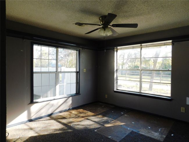 Empty room with ceiling fan and a textured ceiling | Image 22