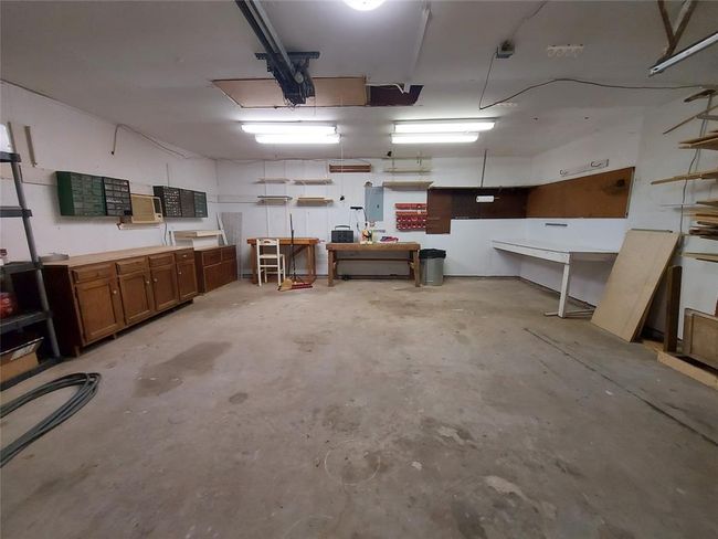 The garage offers plenty of room to park two vehicles and a workshop area and storage space. | Image 47