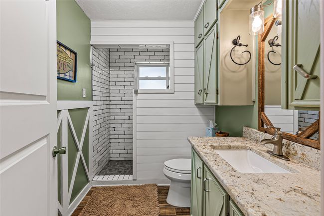 Bathroom with vanity, tiled shower, wood finished floors, and a textured ceiling | Image 17