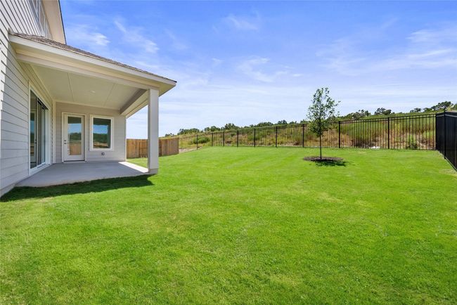 Fenced backyard with a patio area | Image 9