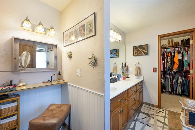 Full bathroom with double vanity, a sink, a spacious closet, and wainscoting | Image 18